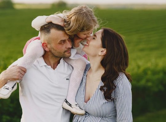 A delightful family moment captured in a lush scenic field, portraying love and happiness.